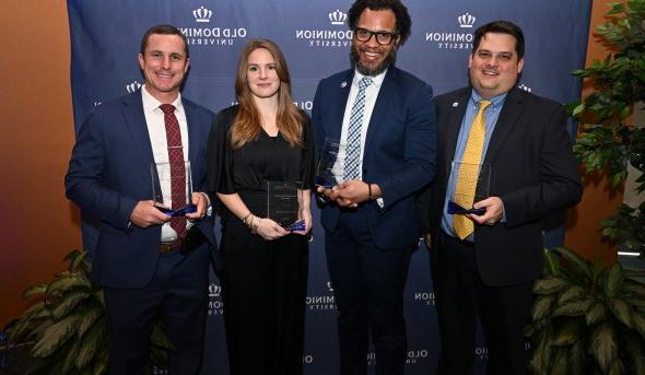 A group of people pose for a photo holding awards